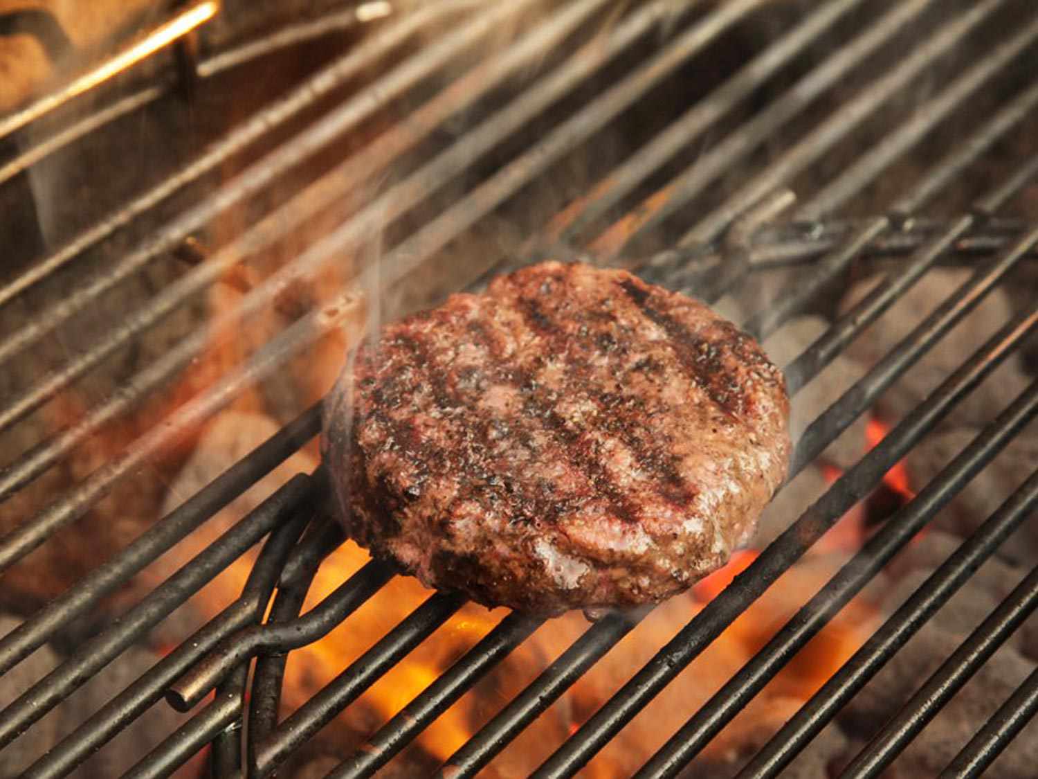 A burger on a grill, demonstrating how grilled burgers cook through all three forms of energy transfer.