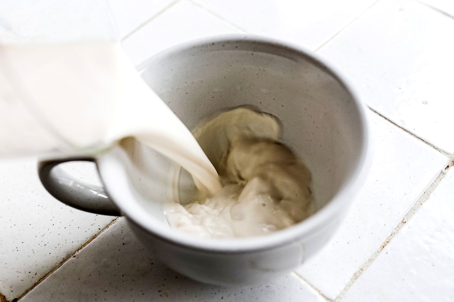 pouring nut milk into a mug