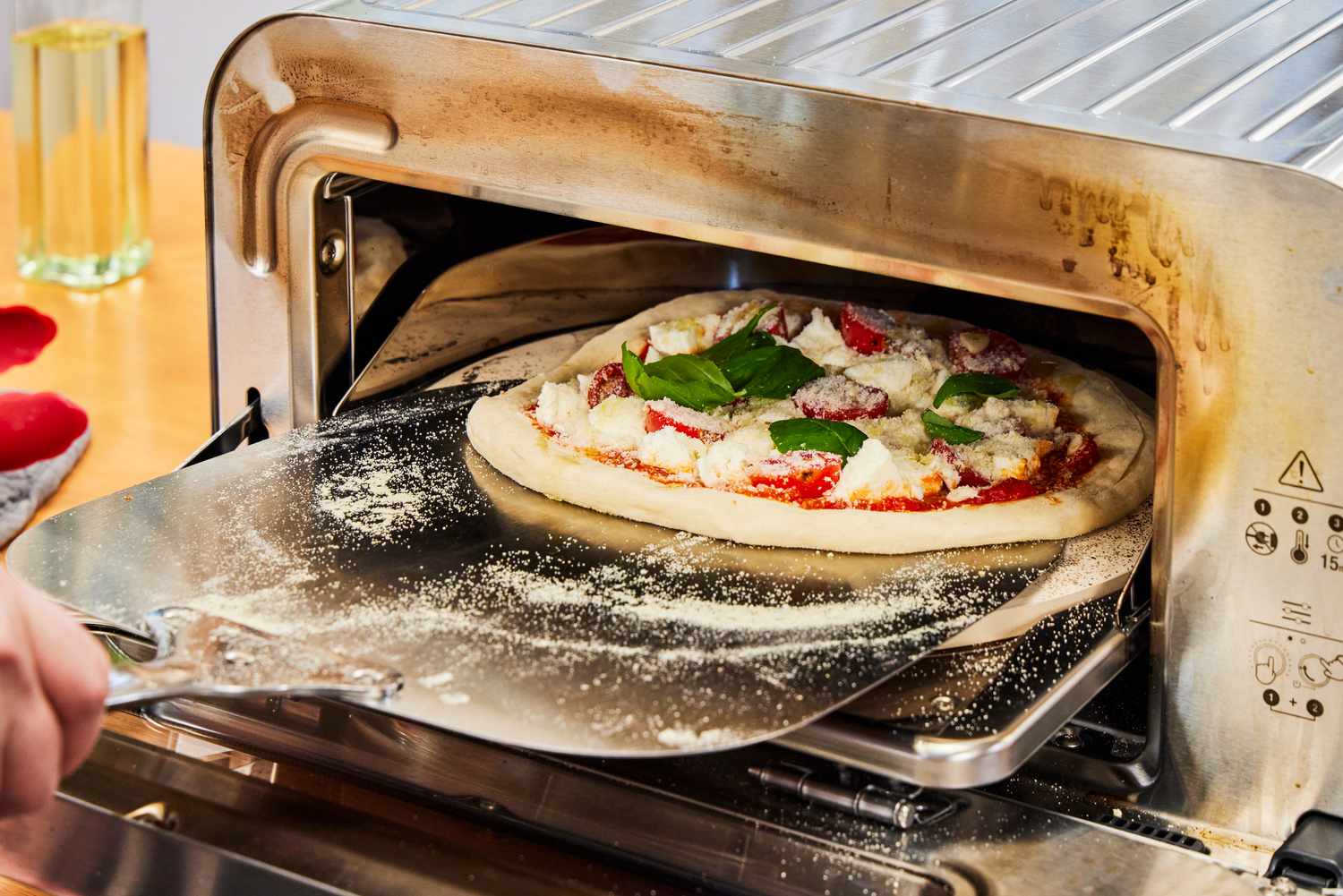 A pizza is placed into the Breville Smart Oven Pizzaiolo Pizza Oven