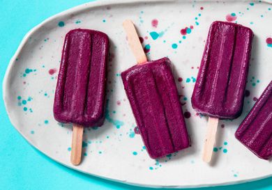 Blueberry yogurt popsicles arranged on a speckled platter