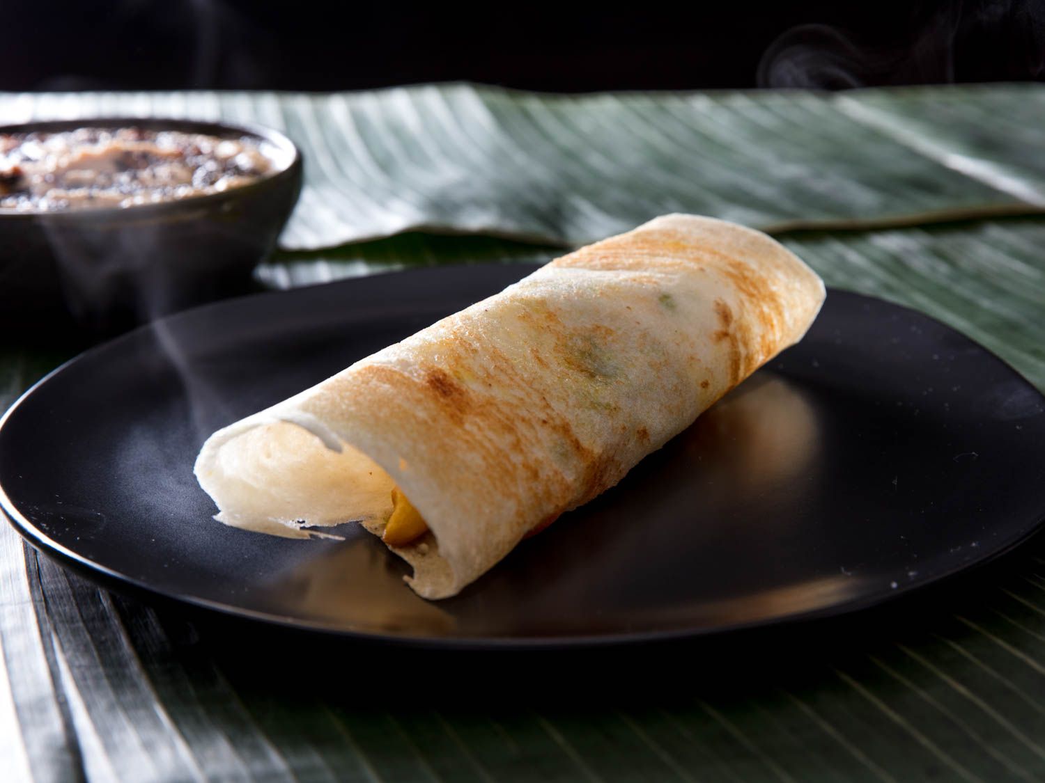Side view of a plated rolled dosa.