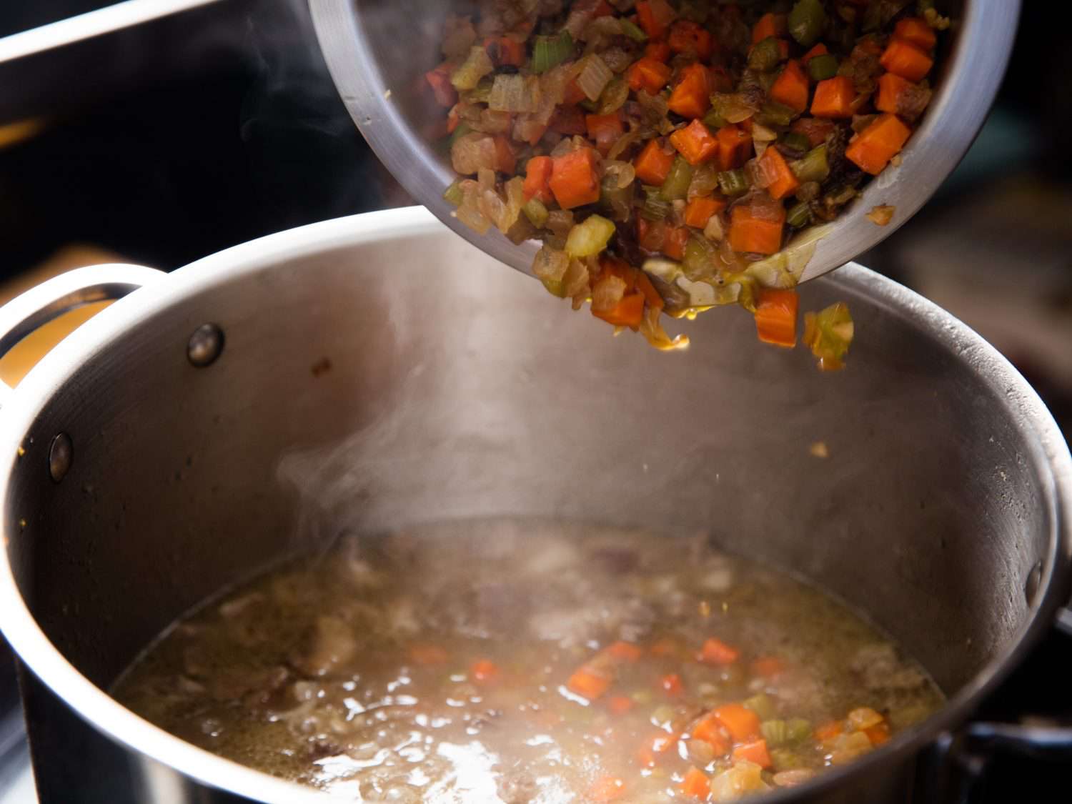 Adding vegetables back to soup pot.