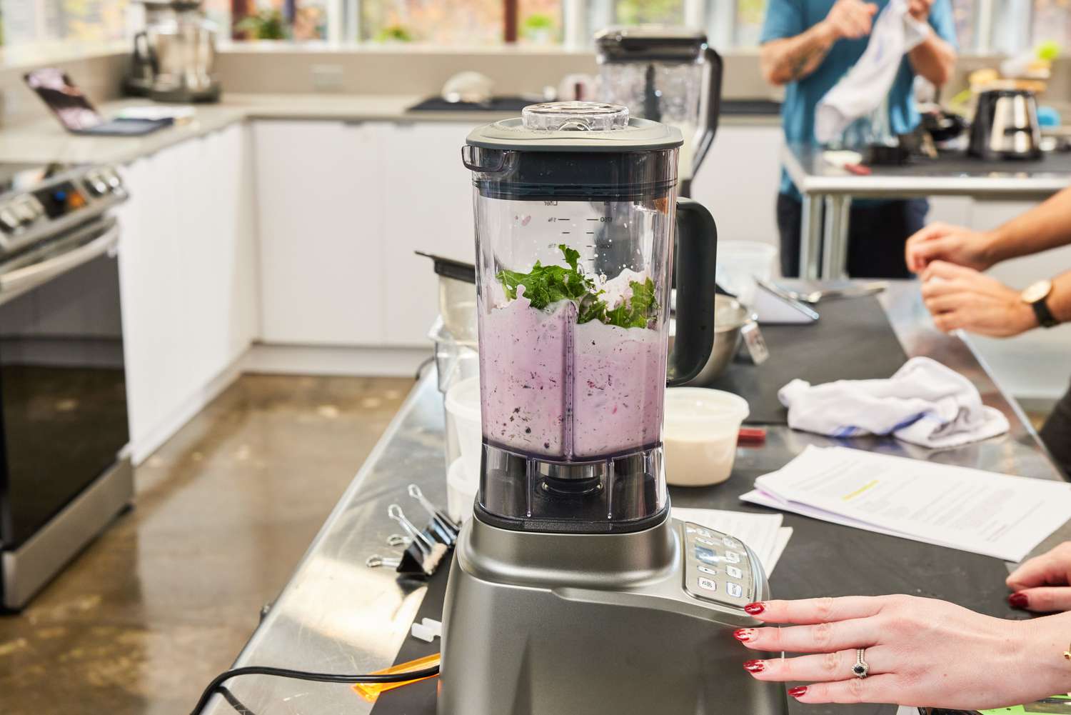 A closeup on a blender in the process of mixing together a smoothie, set in a professional kitchen
