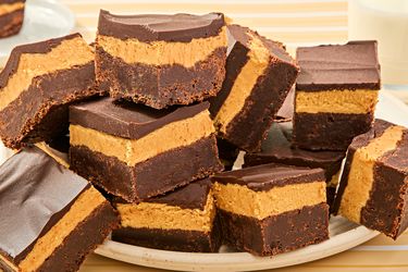 A plate of triplelayer peanut butter brownies with chocolate and peanut butter layers