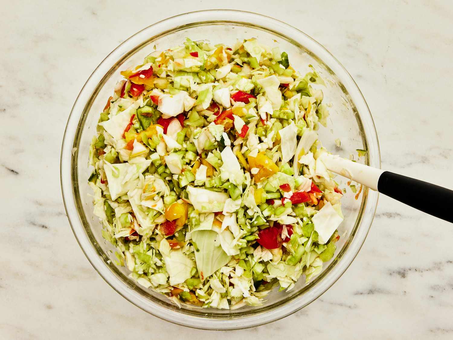 Bowl of Chow Chow with ingredients being mixed together on a marble surface