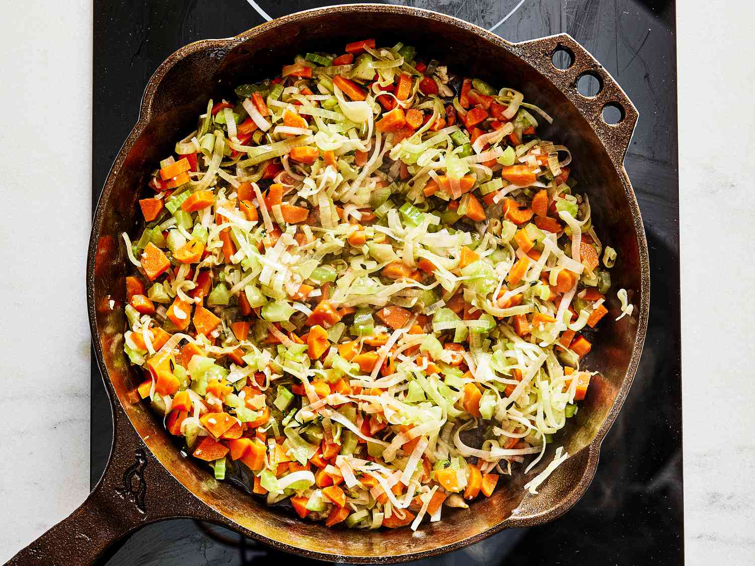 Thinly slices carrots and vegetables cooking in a skillet 