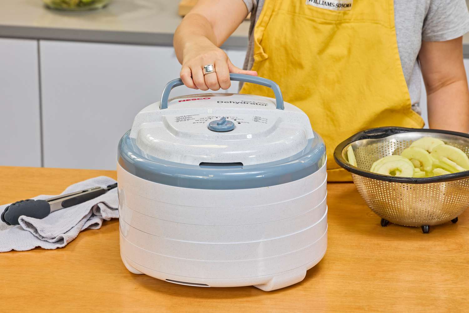 A person holding Nesco Snackmaster Pro Food Dehydrator