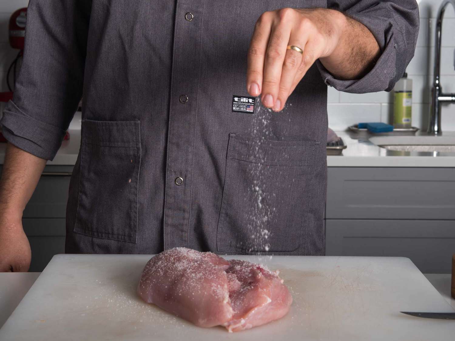 Seasoning turkey breast lobes with salt.