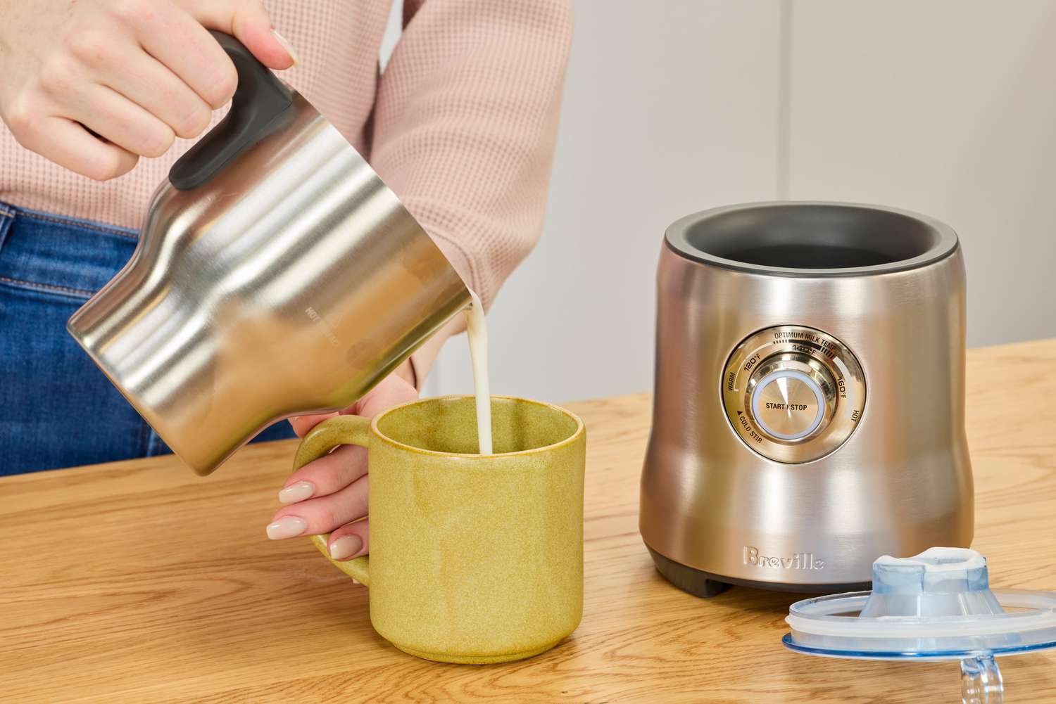 Pouring milk from the Breville's pitcher into a mug.