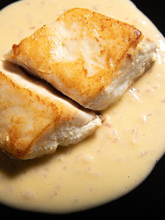 Overhead view of fish plated on top of Beurre Blanc sauce