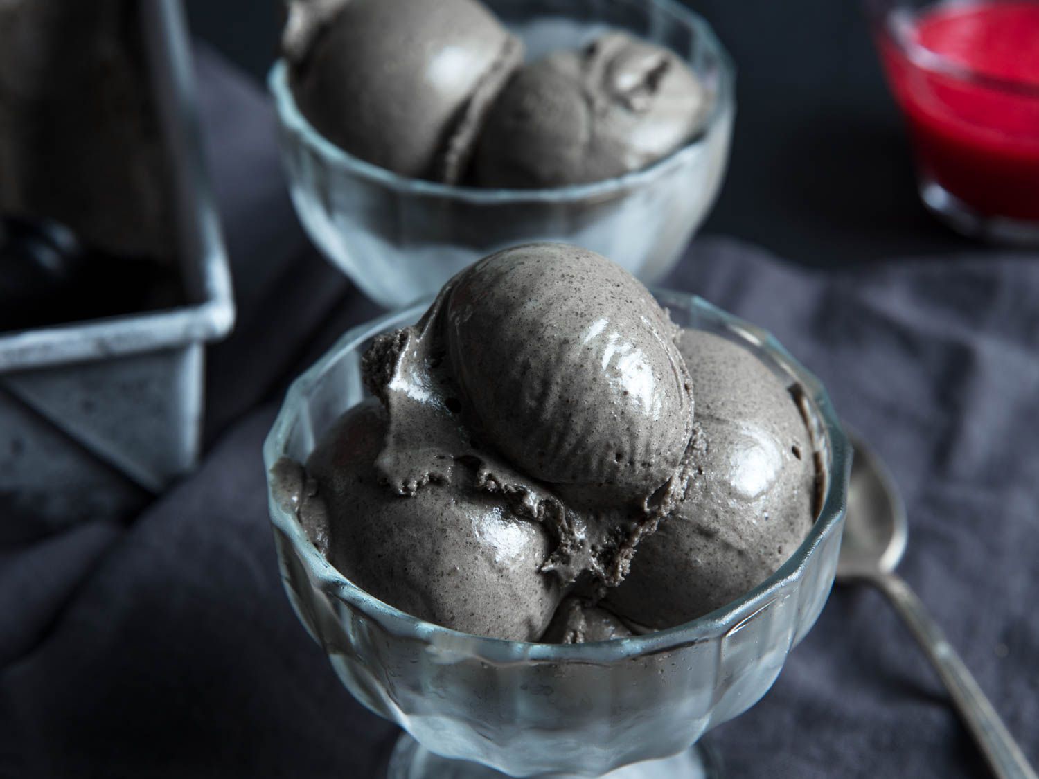 Serving bowls containing scooped black sesame ice cream.
