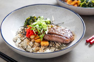 A beefsteak donburi rice bowl topped with scallions