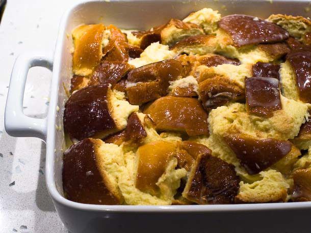 Custard soaked bread arranged in a buttered baking dish.