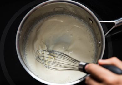 Whisking a homemade mornay sauce in a pan