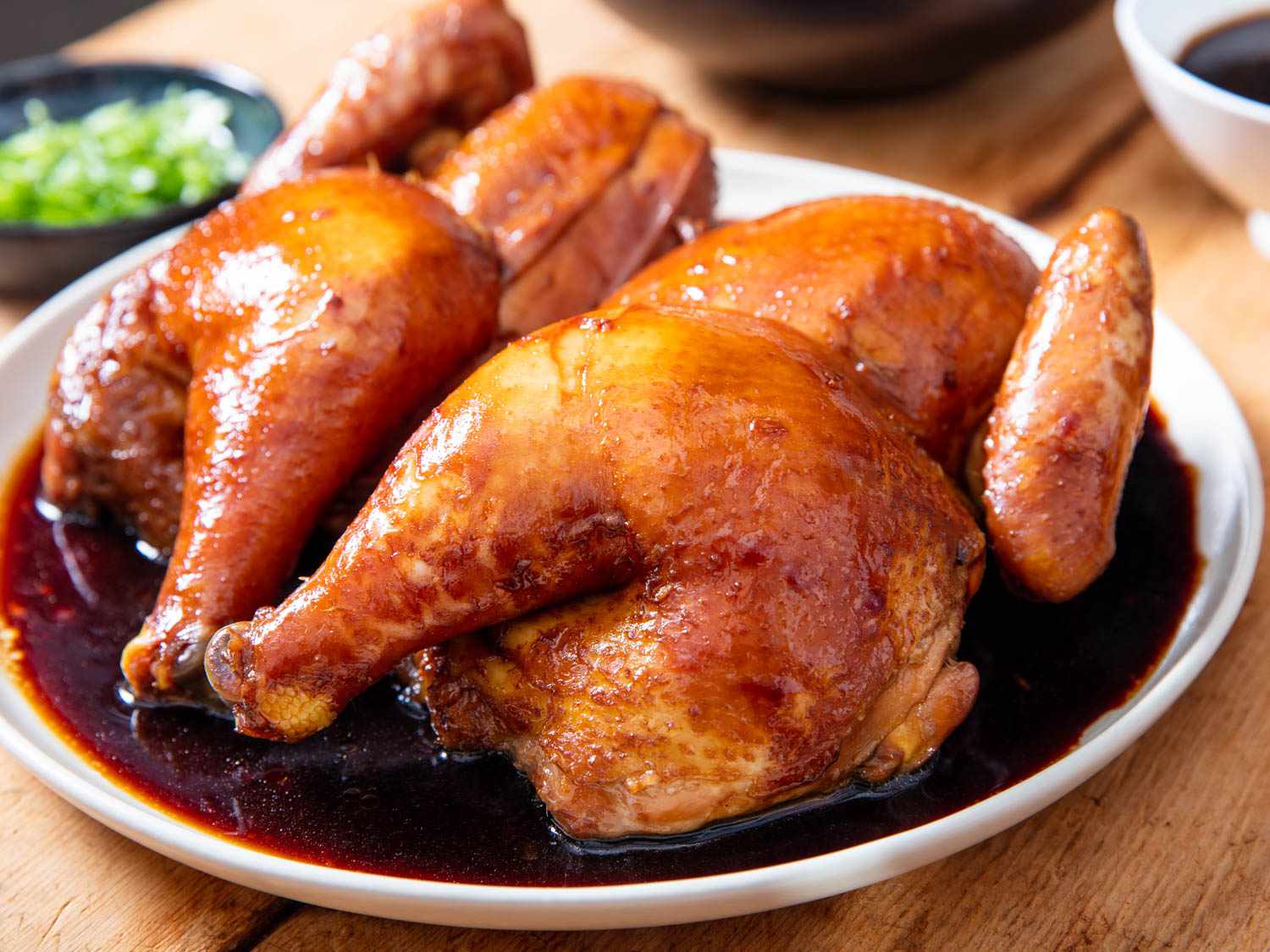 Close-up of the finished poached chicken, plated and lacquered with the reduced poaching liquid.