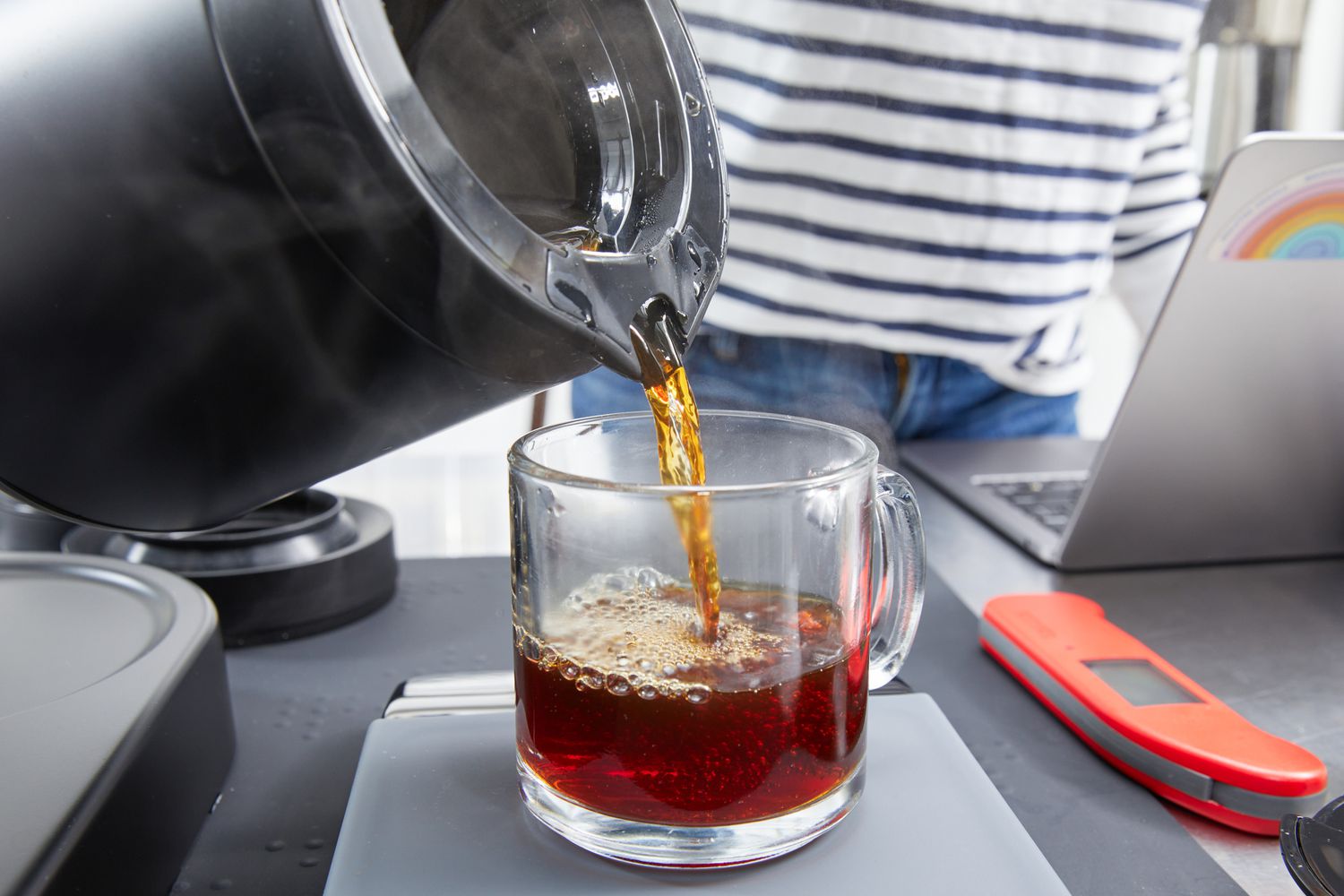 Coffee being poured from the Ratio Six Coffee Maker's carafe into a mug.