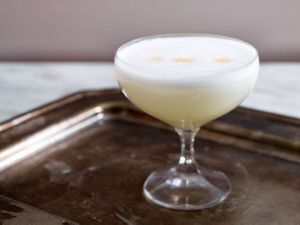 Pisco sour in a cocktail glass on a tray