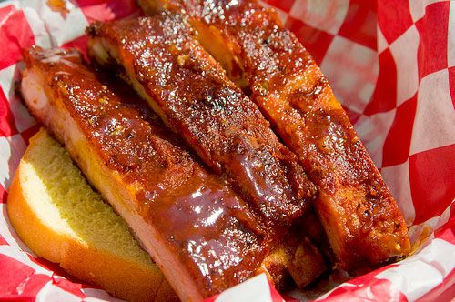 Closeup of Pineapple-Braised Ribs with Honey-Garlic Tomato Glaze, served in a basket on top of a thick slice of toast.