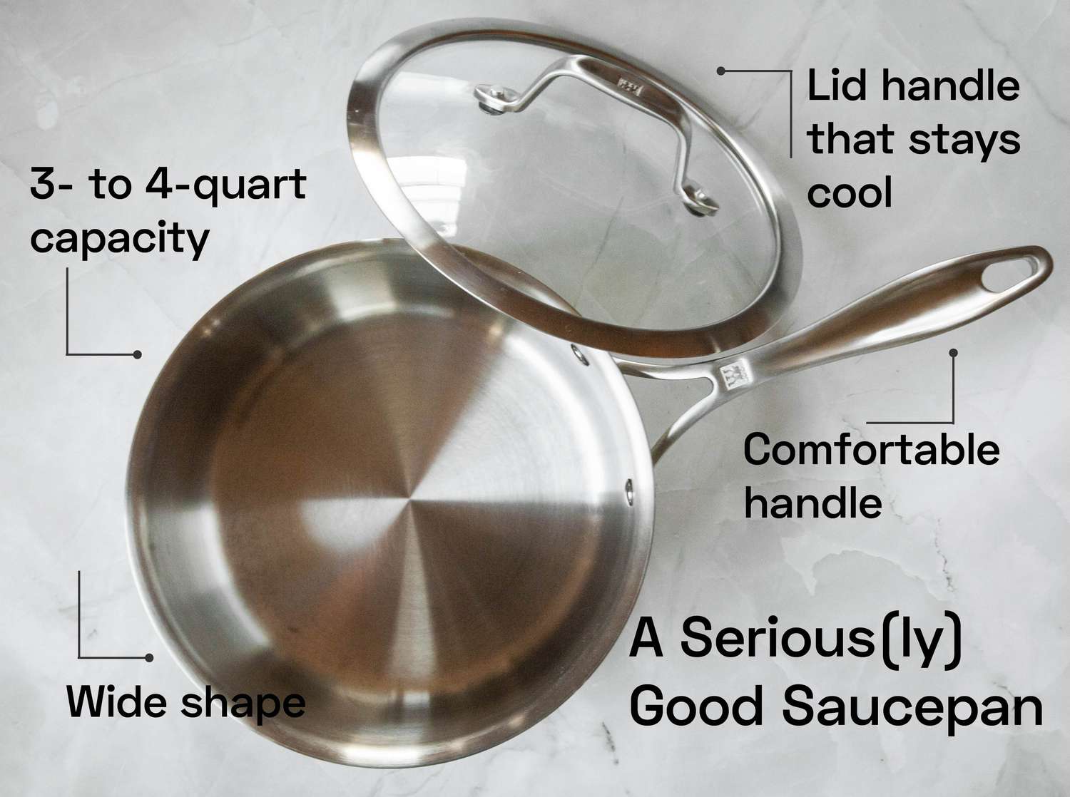 a saucepan with its lid beside on it on a marble countertop