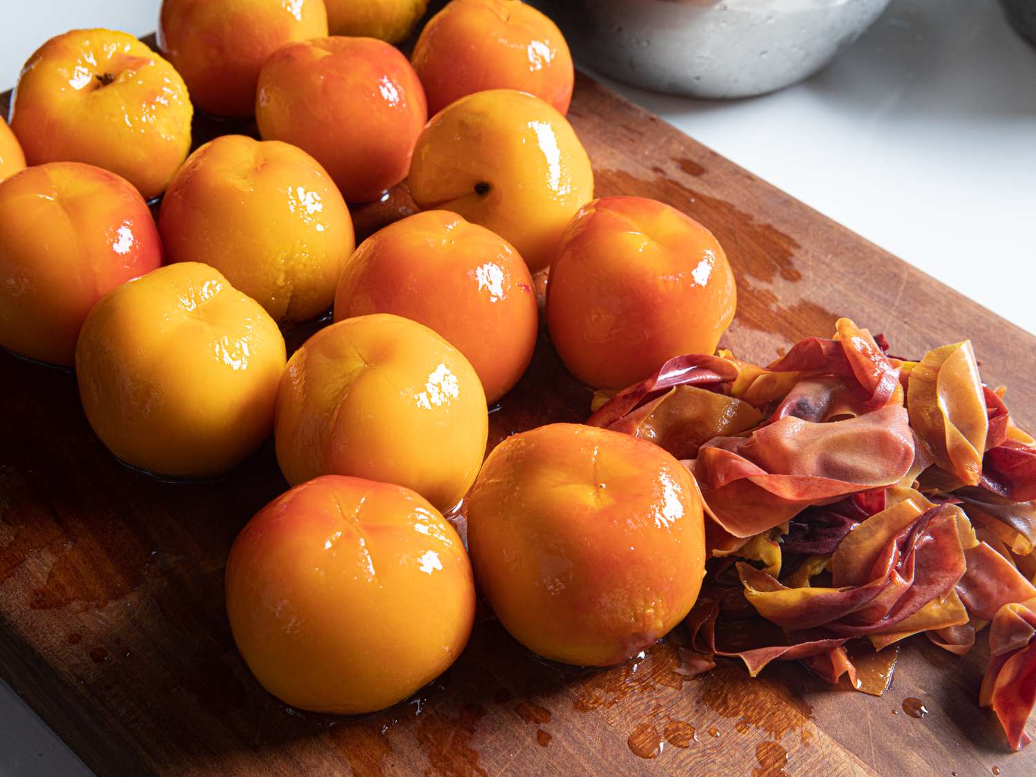 Peeled peaches on a cutting board.