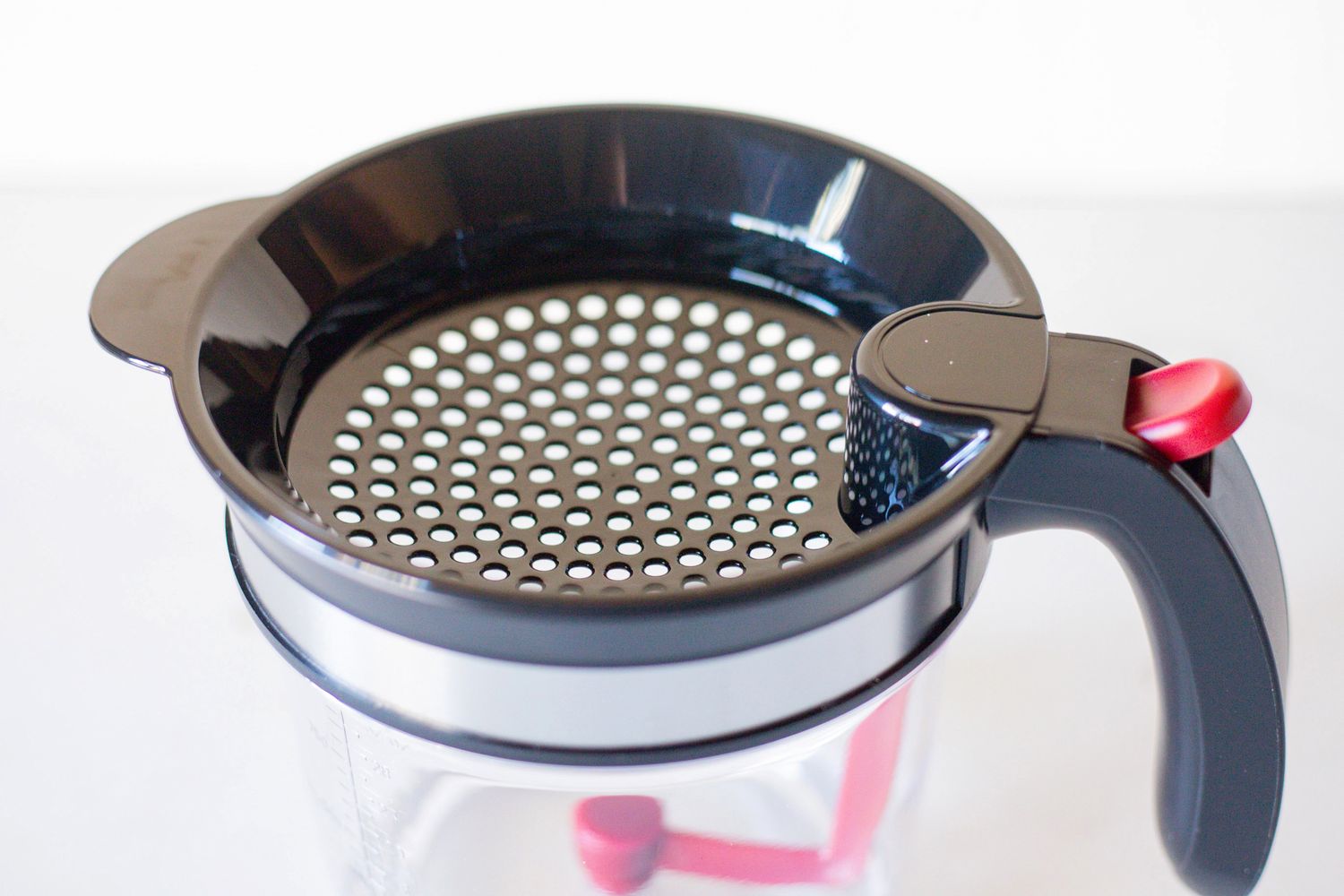 A perforated lid with a handle for a kitchen container or tool