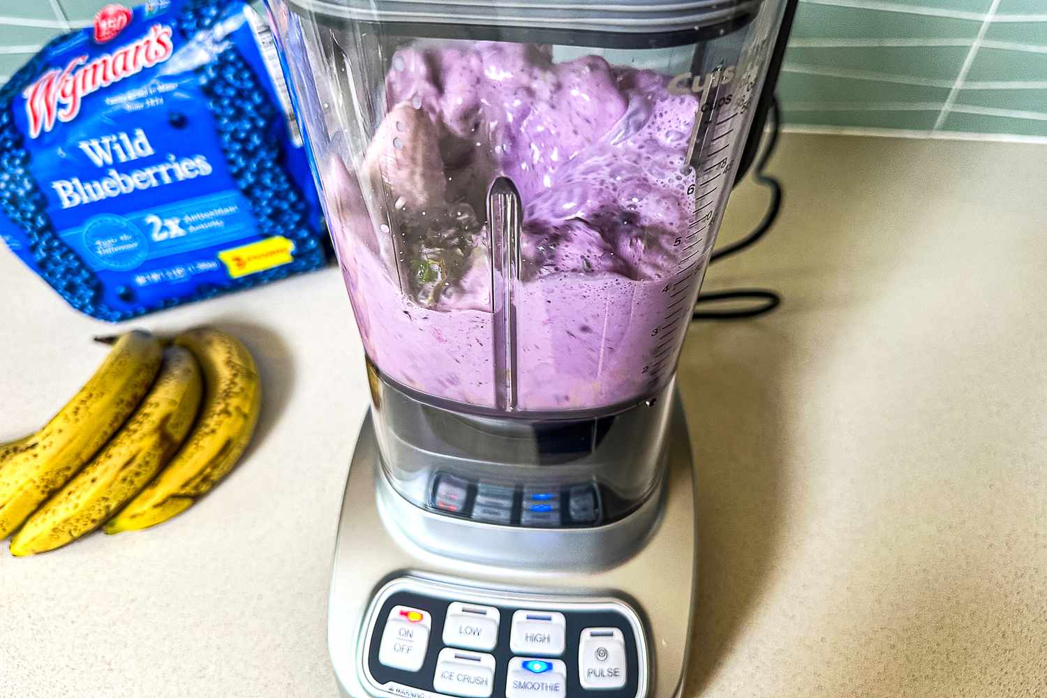 A blueberry and banana smoothie being blended in the Cuisinart Velocity Ultra 7.5 1 HP Blender on a kitchen counter