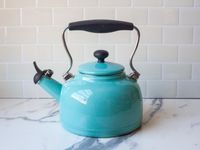 a blue kettle on a marble surface
