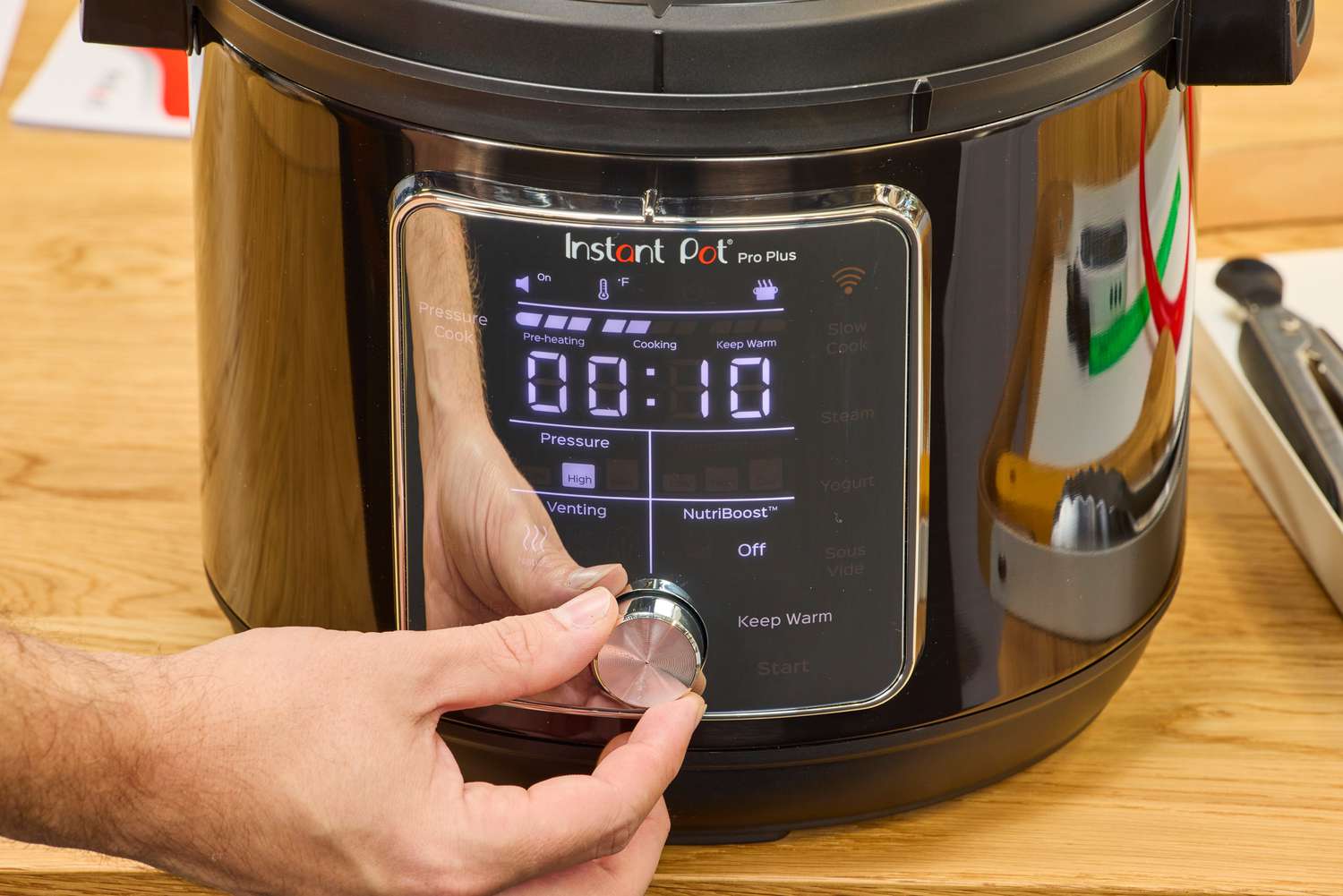 A person adjusts the knob of the Instant Pot Pro Plus Wi-Fi Smart 10-in-1 6-Quart Pressure Cooker