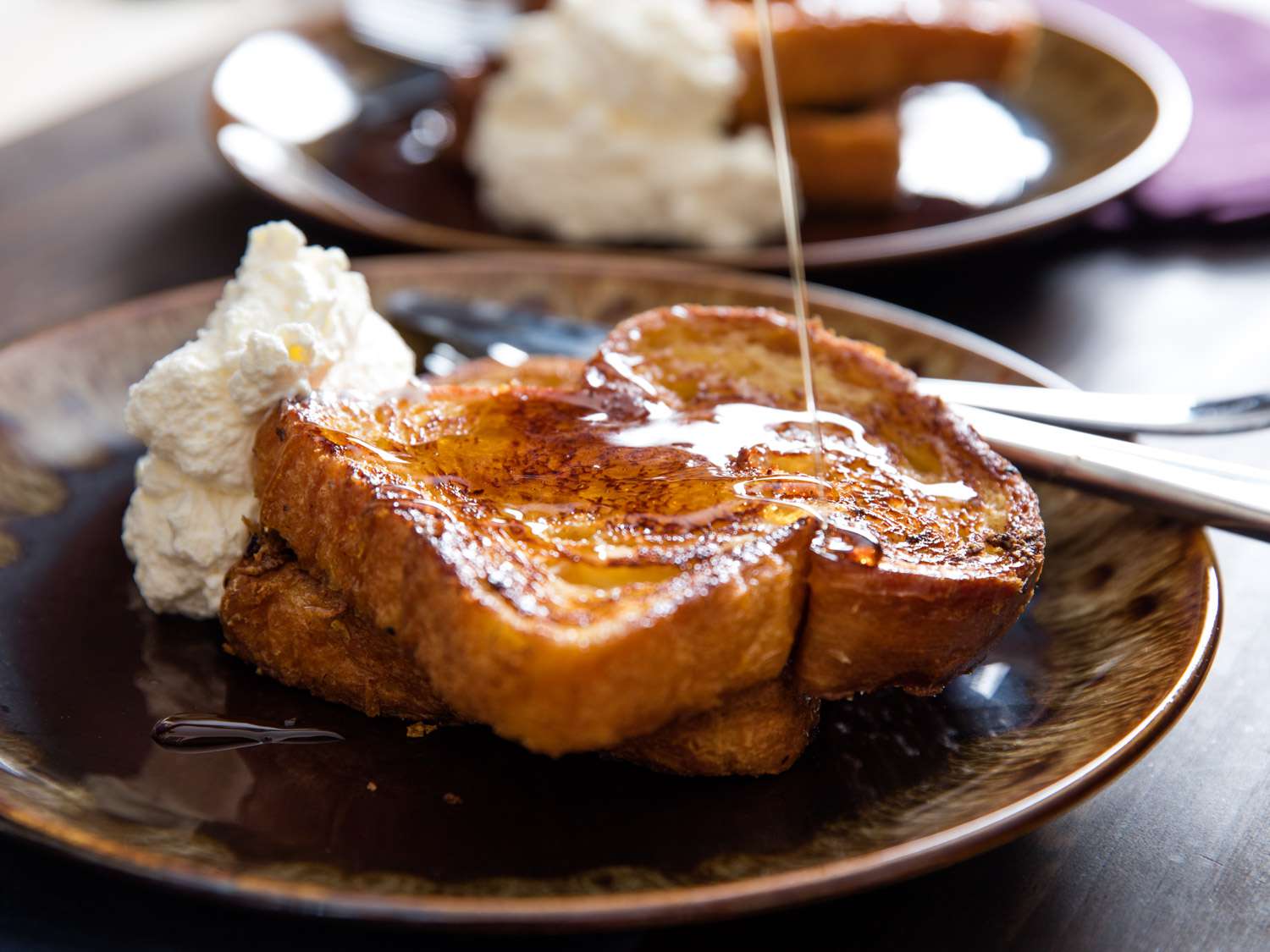 Orange-rum challah French toast, served with whipped crème fraîche and drizzled with maple syrup.