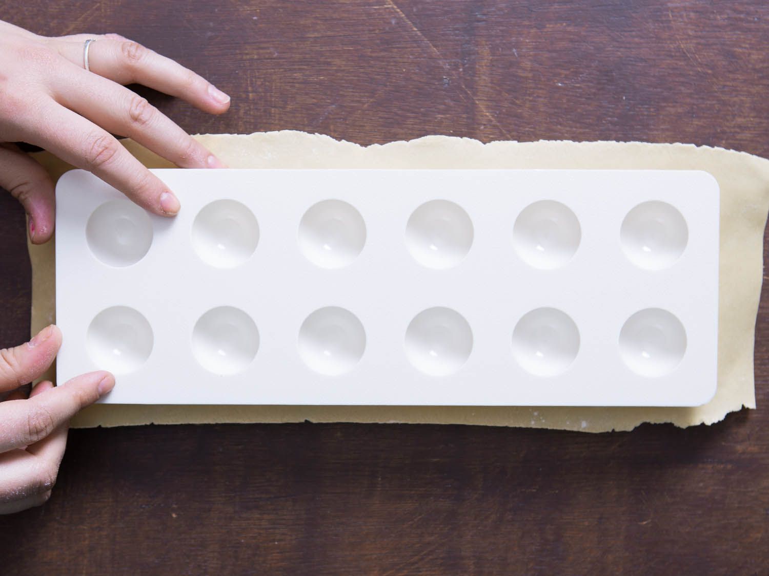 Making depressions in the dough with the plastic portion of the ravioli mold.