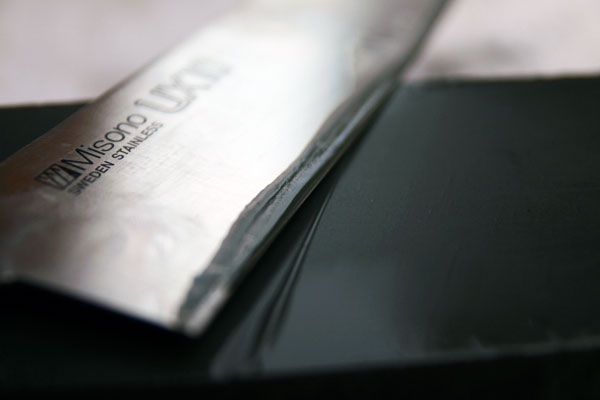 Close-up of a thin film of silty water gathering on a knife's blade
