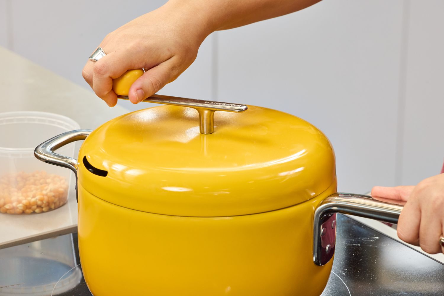 A person turns the crank on the lid of the Popsmith The Popper