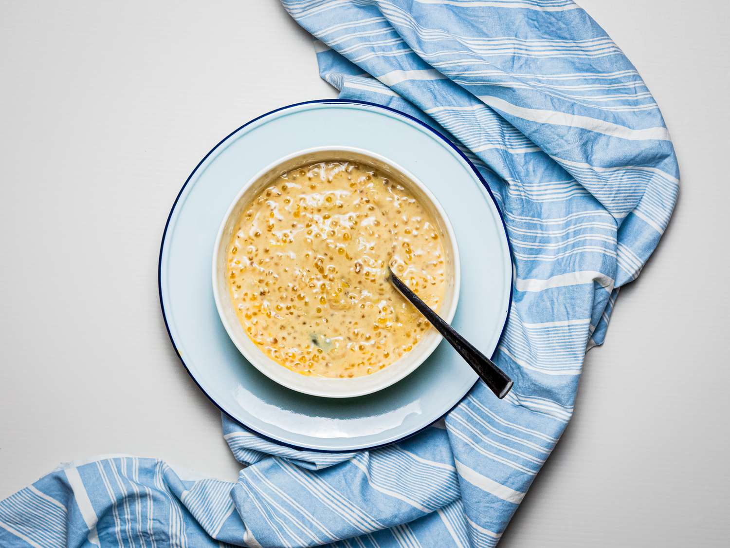 Overhead view of pengat pisang with blue linen