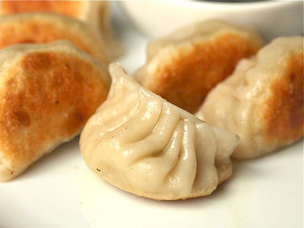 Pan fried dumplings, showing off their crisped, browned bottoms.