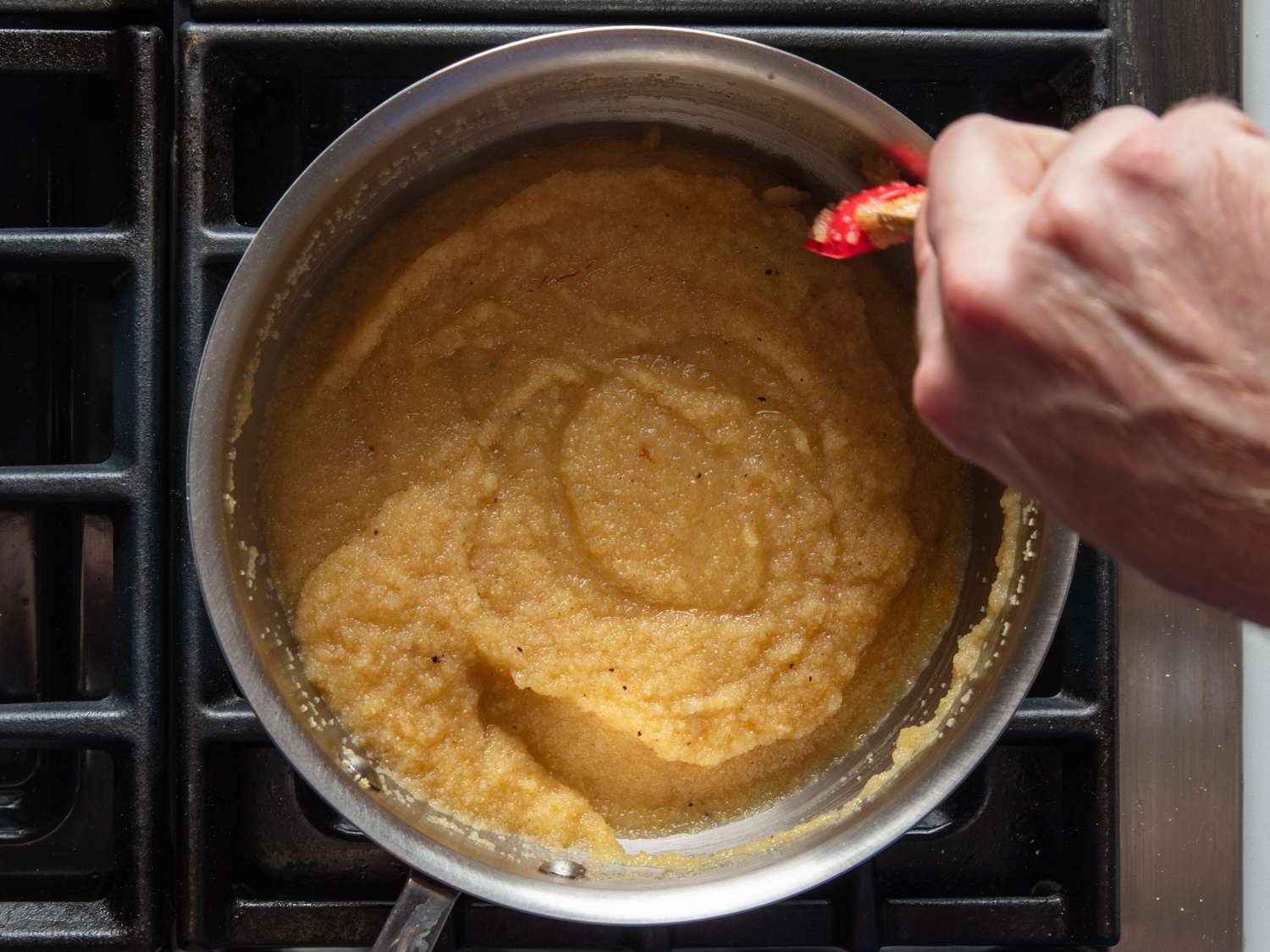 Stirring halva as it cooks in a pot