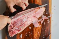 A person slicing meat using the Wusthof Classic Carving Knife