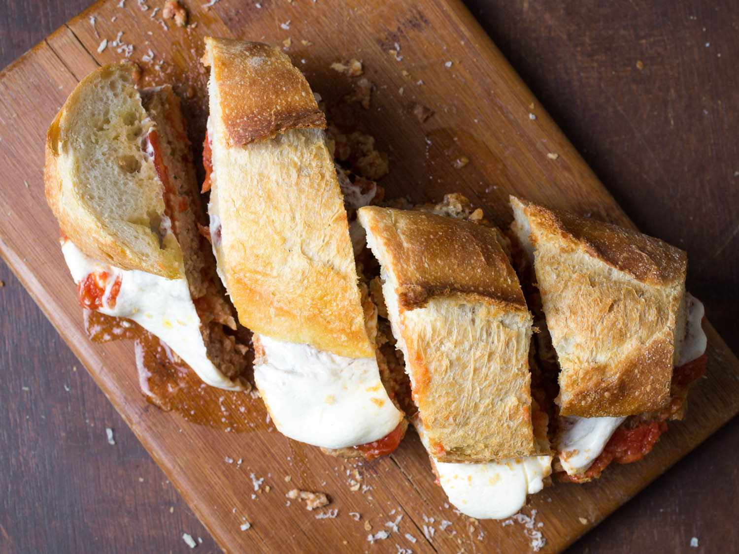 Overhead view of the meatball sandwich, sliced neatly into quarters.