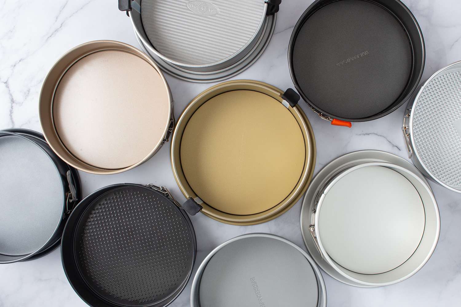 A variety of springform pans displayed in a flat lay arrangement