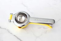 The KitchenAid citrus juicer on a marble countertop.