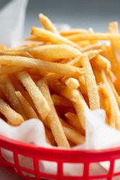 French fries in a red plastic basket 