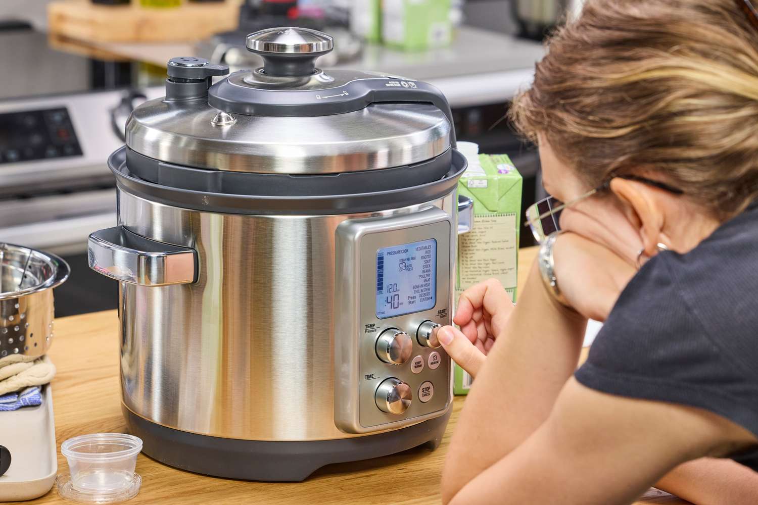 A person presses a button on the front of the Breville the Fast Slow Pro