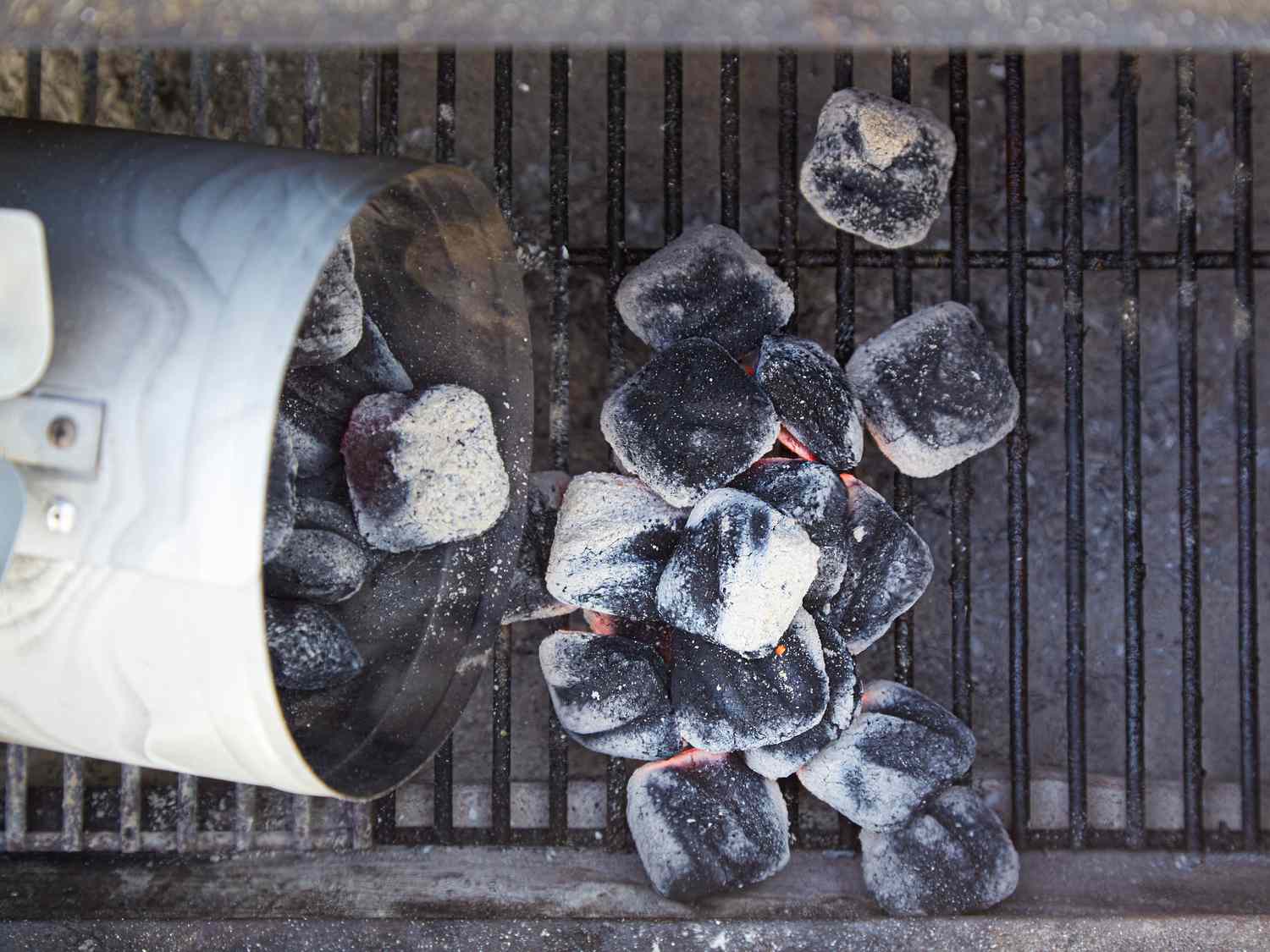 Overhead view of adding charcoal to the grill