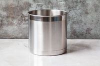 A stainless steel utensil crock on a marble kitchen countertop.
