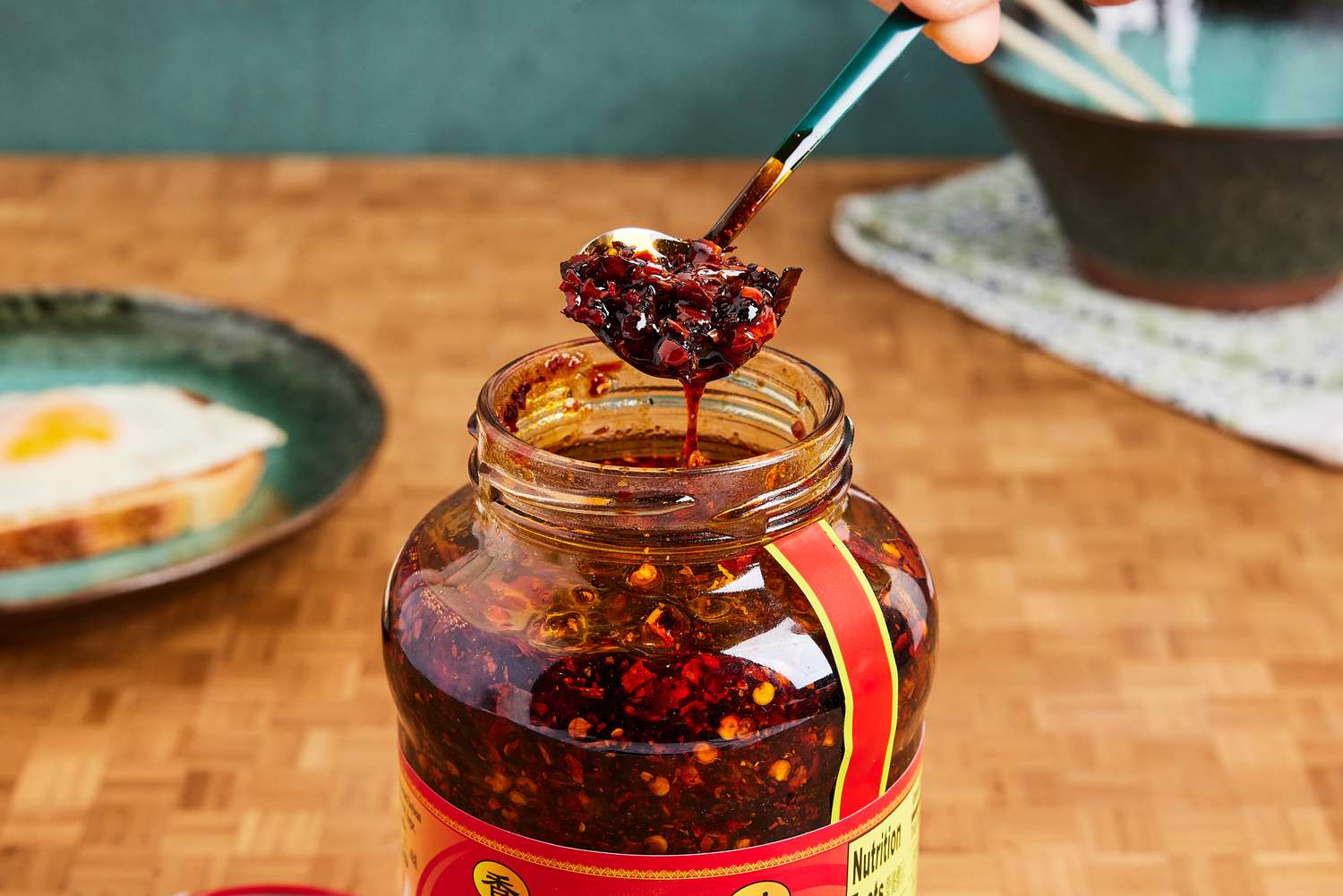 Person scooping Lao Gan Ma Spicy Chili Crisp