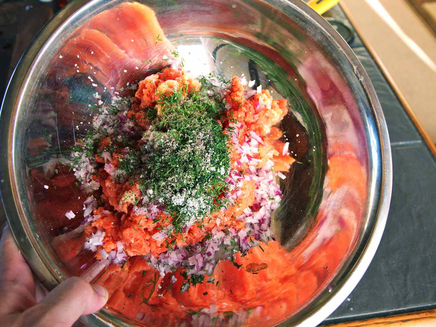 Overhead view of the salmon burger mixture in a large prep bowl, ready to be mixed together.