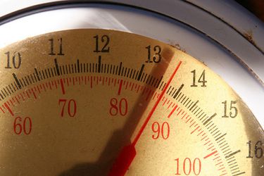 Close up of the face of an analog kitchen scale that reads 13 pounds, 10 ounces.