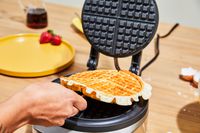 Person flipping waffle over in Breville No-Mess Waffle Maker