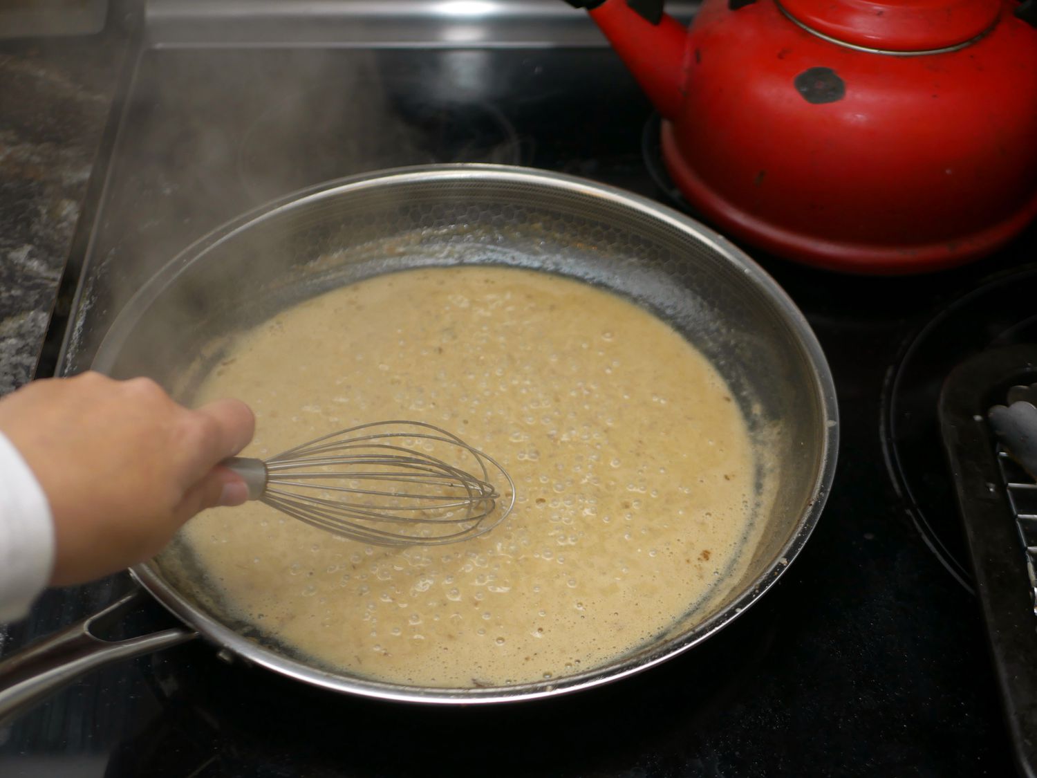 whisking steak au poivre pan sauce in hexclad