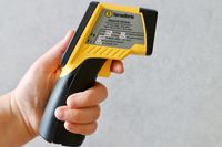 A person holding an infrared thermometer