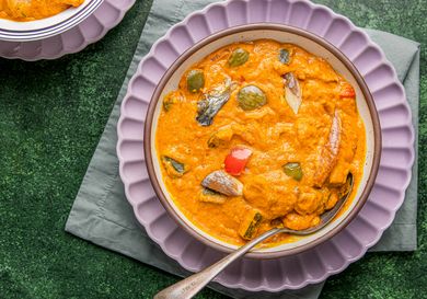 A bowl of Nigerian egg sauce served on a green placemat with a spoon